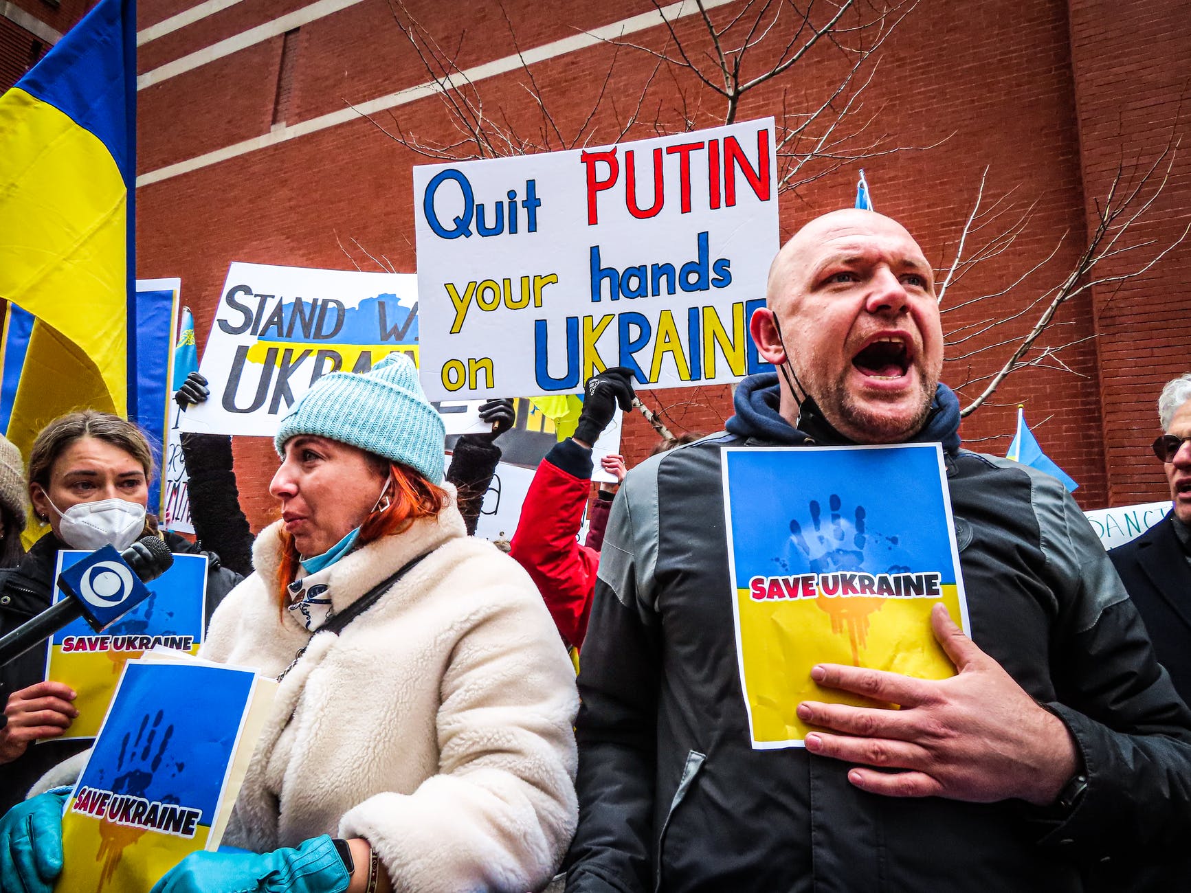 people holding anti war signs and protesting in the street